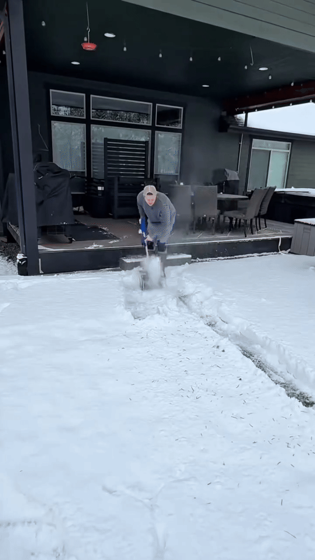 Glacio throwing snow off a walkway while the user walks